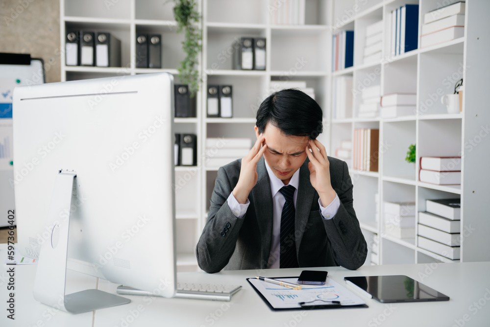 Asian businessman is stressed, bored, and overthinking from working on a tablet at the office. Asian businessman is stressed, bored, and overthinking from working on a tablet at the office.