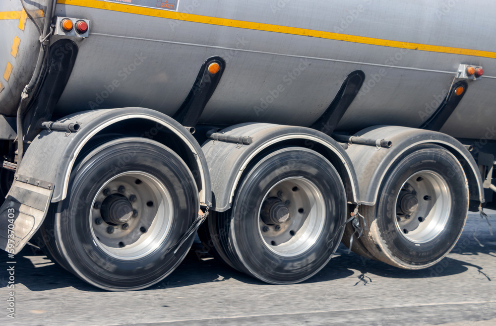 View of the rear wheels of a cistern truck while driving with the axle raised - obrazy, fototapety, plakaty 
