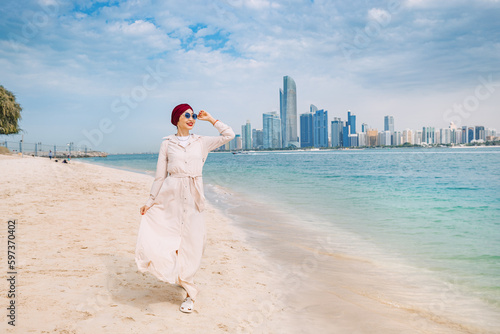 Photography Young woman walks along sandy beach and takes occasional glances toward the impr