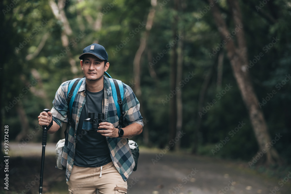 Hikers use trekking pole with backpacks walking through on the road in the forest. hiking and adventure concept. Hikers use trekking pole with backpacks walking through on the road in the forest. hiking and adventure concept.