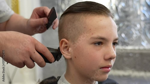 Close-up of barber doing haircut at hair salon or barber shop