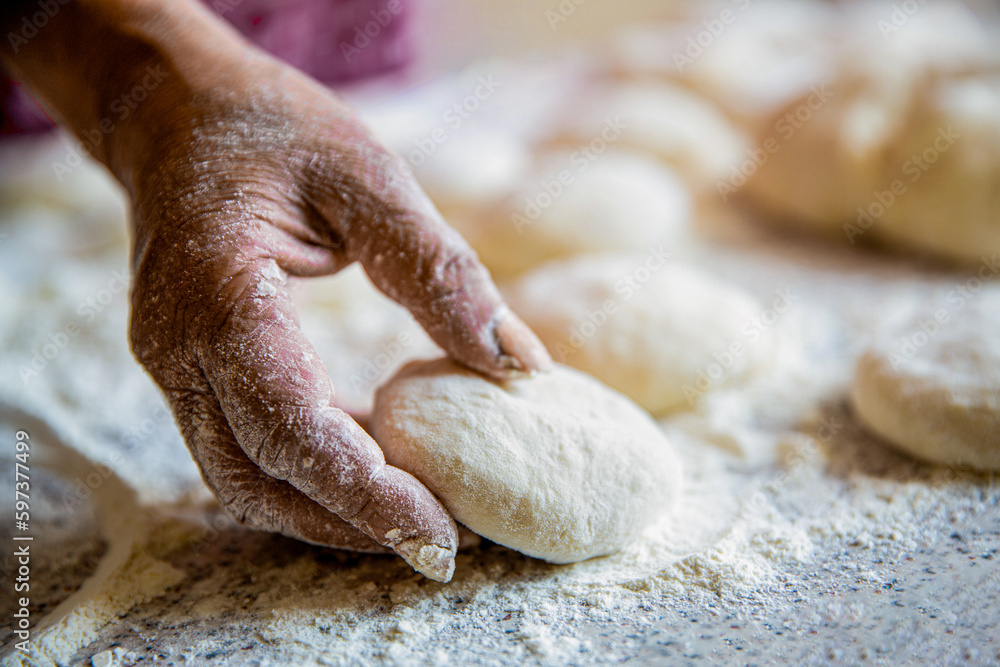Hands pie dough. Cooks doughs for baking, pieces of raw dough. Womans hands rolling dough for pies. Baking at home. Homemade cakes dough in the women's hands. Process of making pies