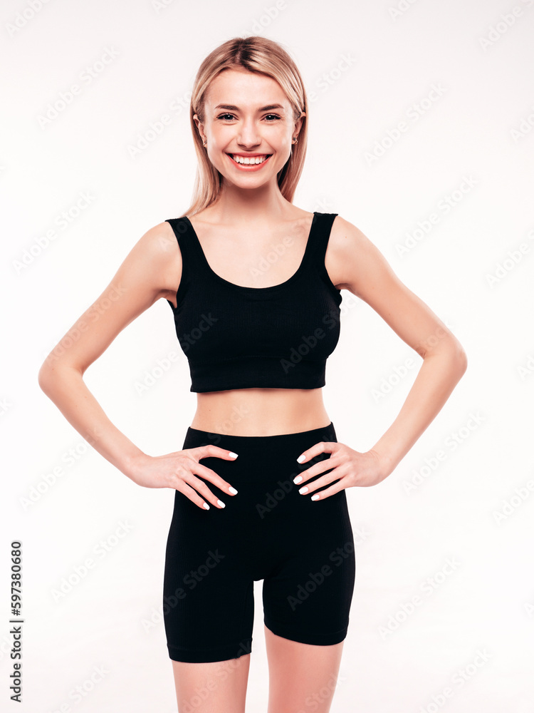 Young beautiful smiling blond female in black cycling shorts clothes. Sexy carefree woman posing on white background in studio. Positive model having fun indoors. Cheerful and happy Young beautiful smiling blond female in black cycling shorts clothes. Sexy carefree woman posing on white background in studio. Positive model having fun indoors. Cheerful and happy