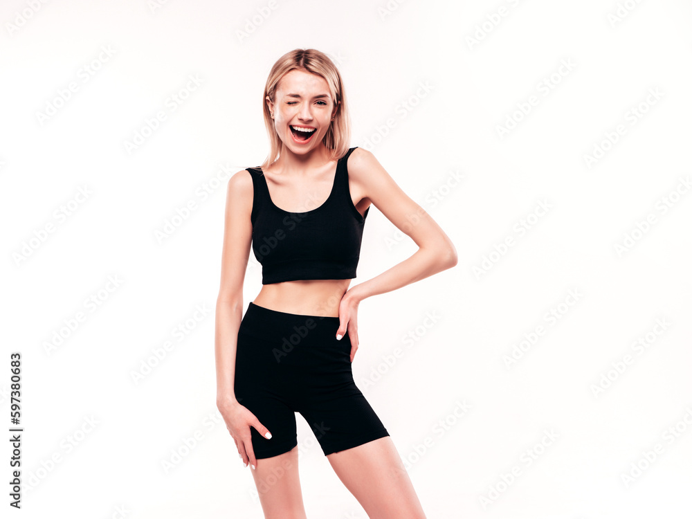 Young beautiful smiling blond female in black cycling shorts clothes. Sexy carefree woman posing on white background in studio. Positive model having fun indoors. Cheerful and happy Young beautiful smiling blond female in black cycling shorts clothes. Sexy carefree woman posing on white background in studio. Positive model having fun indoors. Cheerful and happy