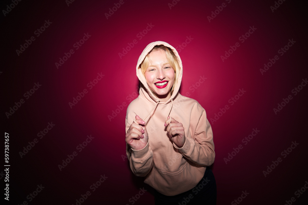Fototapeta premium A cheerful woman dancing and having fun isolated on magenta background. Viva magenta, color of the year.