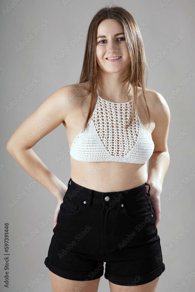 Cheerful happy smiling woman poses in a knitted or crocheted white top in photo studio Cheerful happy smiling woman poses in a knitted or crocheted white top in photo studio