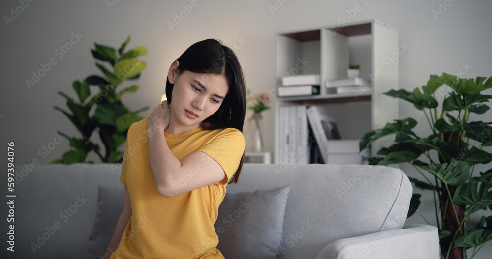 Young Asian woman shoulder pain in the living room at home. Young Asian woman shoulder pain in the living room at home.