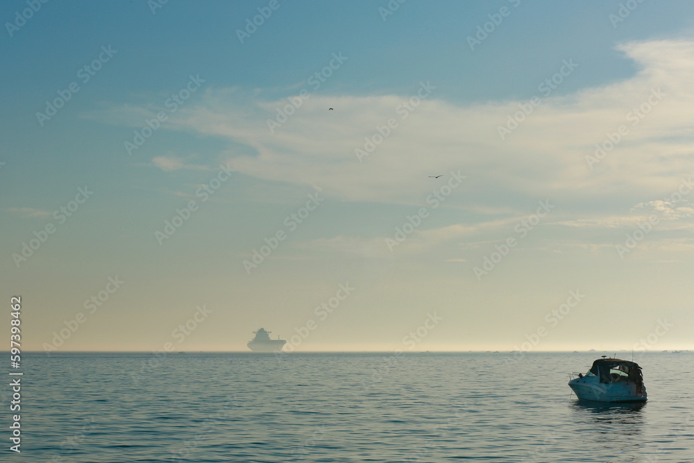 Seascape. A ship on the horizon in the sea. Sky and sea.