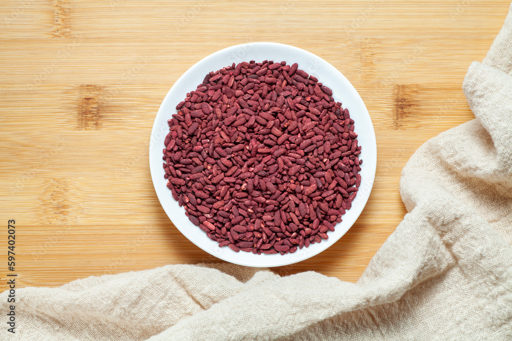 Red yeast rice in a ceramic dish. Chinese traditional food and medicine. Red yeast rice in a ceramic dish. Chinese traditional food and medicine.