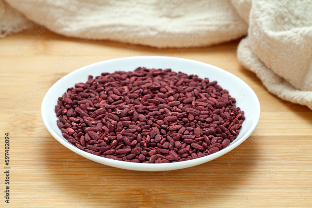 Red yeast rice in a ceramic dish. Chinese traditional food and medicine. Red yeast rice in a ceramic dish. Chinese traditional food and medicine.