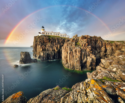 Fotografiet Rainbow over Neist Point Lighthouse on the green cliffs of the Isle of Skye, Sco