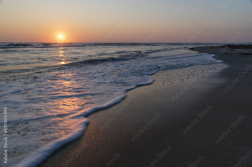 Alba sul mare con il sole che riflette sull'acqua.