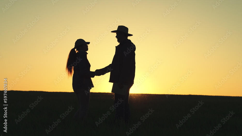 silhouette handshake farmer business. sunset hands. field wheat farm. farming concept. man woman business partner. deal group people. teamwork. Collective farmers shake hands wheat field. Sun tablet.
