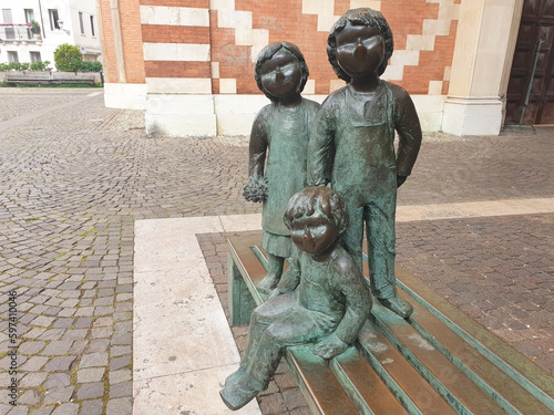 Sculpture of children sitting on a bench near the Carmini church in Vicenza. photo