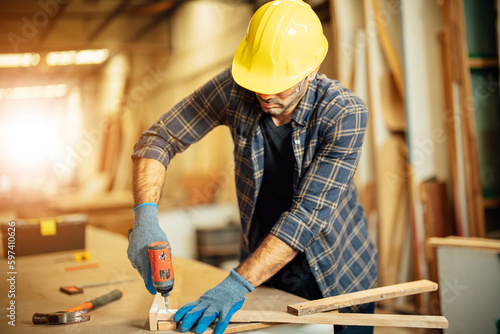 Carpenter man attend to making masterpiece woodworks handcrafted furniture fine measure in wood workshop.