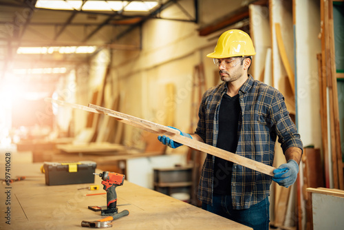 Carpenter man attend to making masterpiece woodworks handcrafted furniture fine measure in wood workshop.