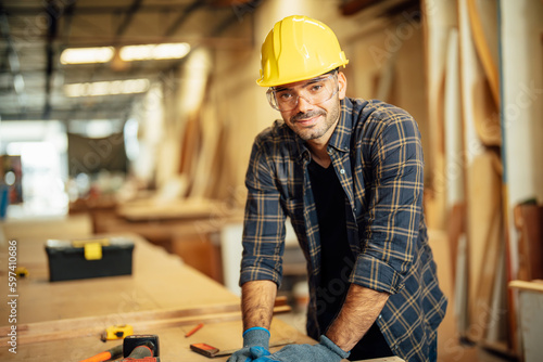 Carpenter man attend to making masterpiece woodworks handcrafted furniture fine measure in wood workshop.