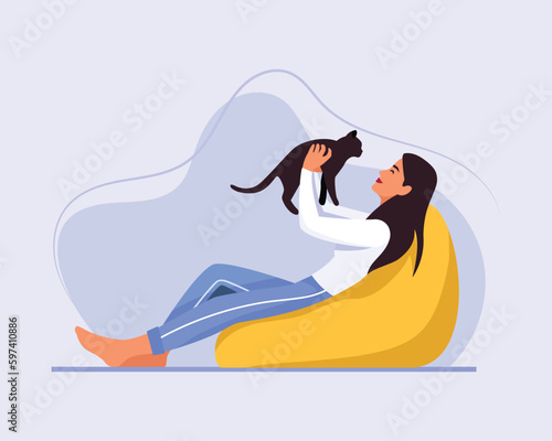 light-skinned girl with long hair sits on a bean bag chair with a cat