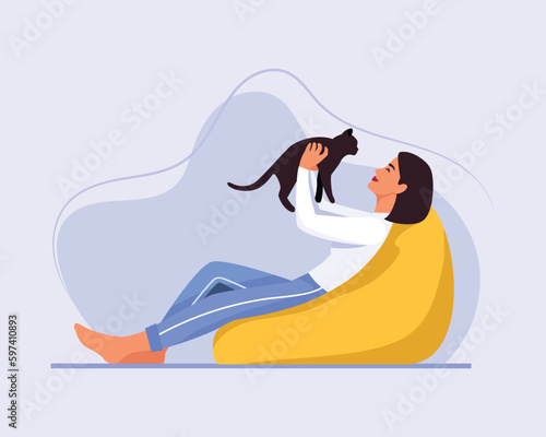 light-skinned girl with short hair sits on a bean bag chair with a cat