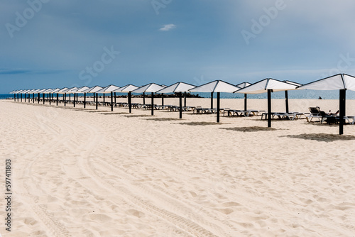 Beach with no one in the Algarve  in spring  with modern umbrellas but empty of tourists