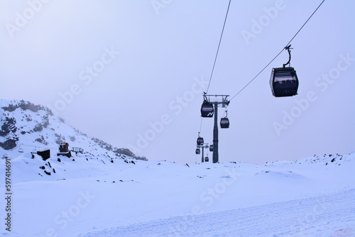 Cable cars going up and down snow blanketed slopes of the mountain while a snow storm building up. Mt Ruapehu, Whakapapa Sky Field, New Zealand