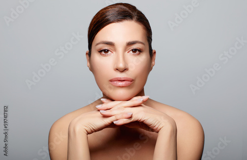 Beautiful woman with a flawless fresh clean skin posing in studio. Beauty and skin care concept