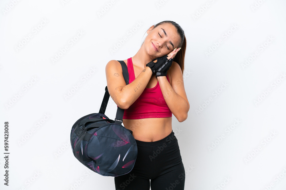Young sport woman with sport bag isolated on white background making sleep gesture in dorable expression Young sport woman with sport bag isolated on white background making sleep gesture in dorable expression