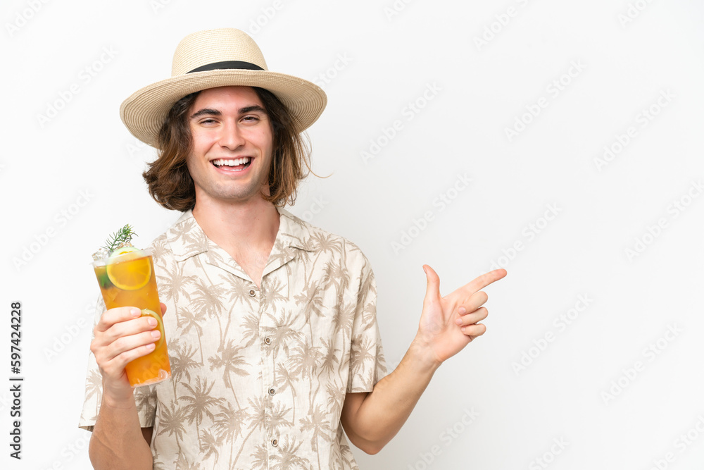 Young handsome man holding a cocktail isolated on white background pointing finger to the side and presenting a product Young handsome man holding a cocktail isolated on white background pointing finger to the side and presenting a product