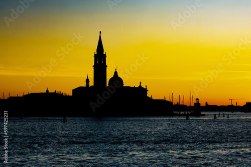 Beautiful picturesque panoramic view on abbey San Giorgio Maggiore (Abbazia di San Giorgio Maggiore) at sunset. Silhouette of Isola di San Giorgio Maggiore. Venice, Italy.