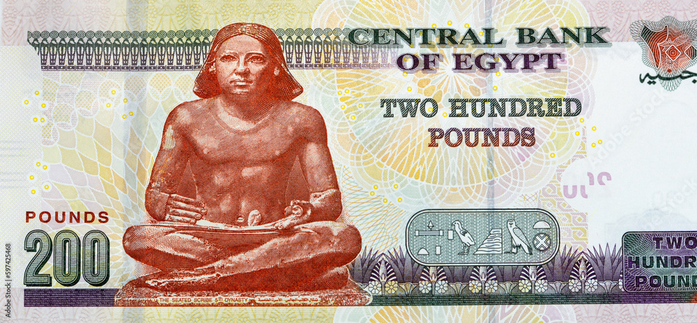Large fragment of the reverse side of 200 LE EGP two hundred Egyptian pounds cash money banknote paper series 2022 features the seated scribe of ancient Egypt, selective focus of Egyptian money - obrazy, fototapety, plakaty 