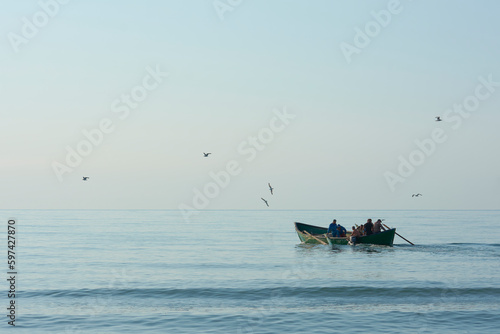 fishing boat with fishermen at sea