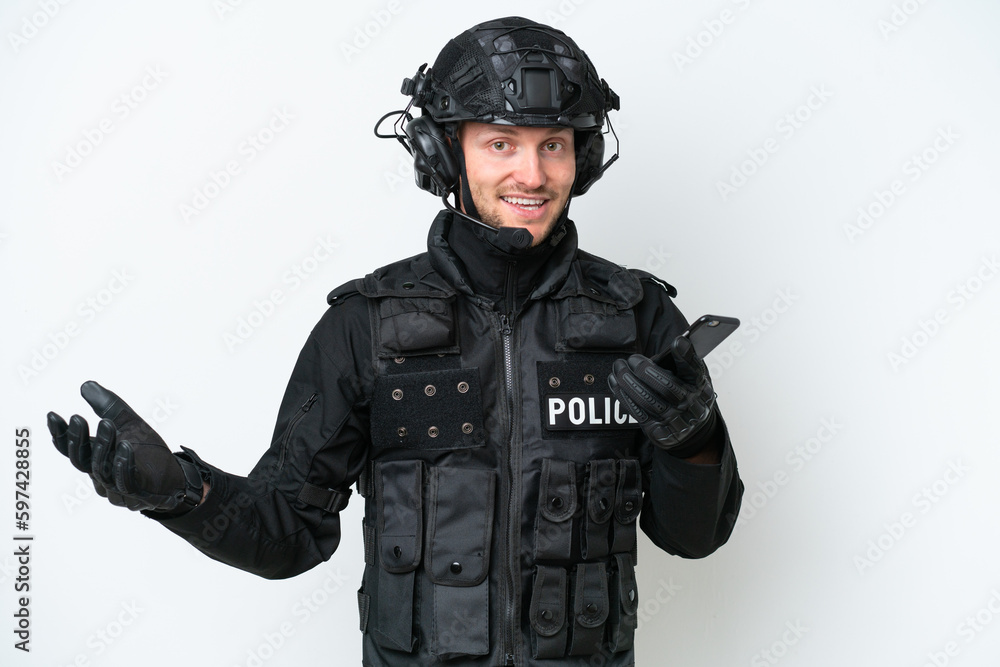 SWAT man over isolated white background keeping a conversation with the mobile phone with someone SWAT man over isolated white background keeping a conversation with the mobile phone with someone
