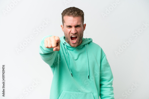 Young handsome caucasian man isolated on white background frustrated and pointing to the front © luismolinero