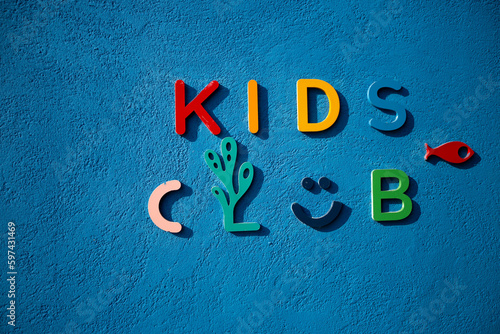The letters kid club on the blue wall