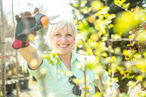 Gärtnerin in der Baumschule schneidet die Äste