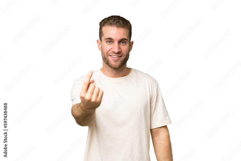 Young handsome caucasian man isolated on green chroma background doing coming gesture Young handsome caucasian man isolated on green chroma background doing coming gesture