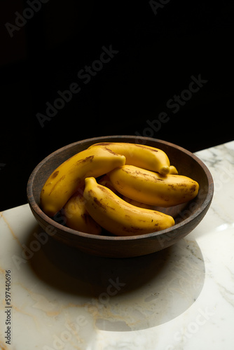Banana dessert in a wooden bowl on marble table