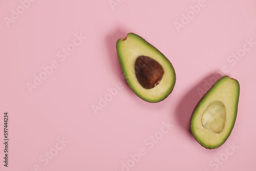Raw ripe avocado on pink background, weight loss concept