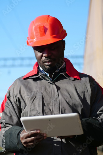 African american railway man with tablet computer at freight train terminal photo