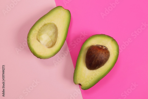 Raw ripe avocado on pink background, weight loss concept
