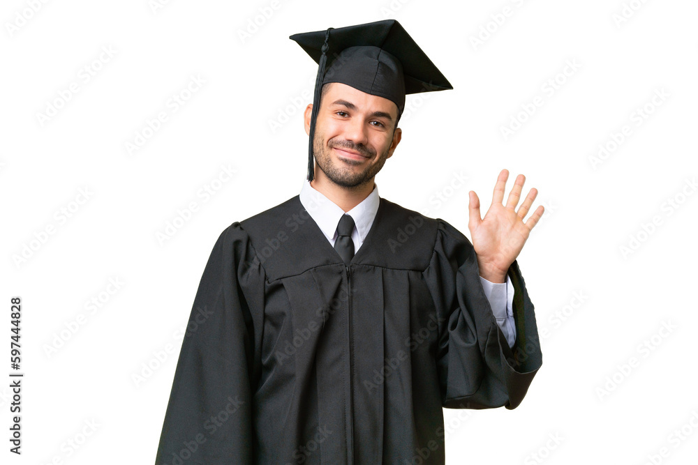 Young university graduate man over isolated background saluting with hand with happy expression Young university graduate man over isolated background saluting with hand with happy expression