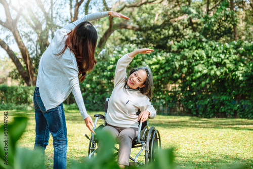 Asian grandmother in wheelchair with daughter is enjoying at the park in the morning