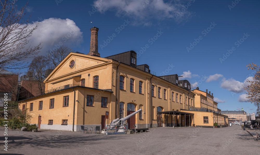 The old maritime torpedo shop house Torpedverkstaden on the island Skeppsholmen, a sunny spring day with cumulus clouds in Stockholm