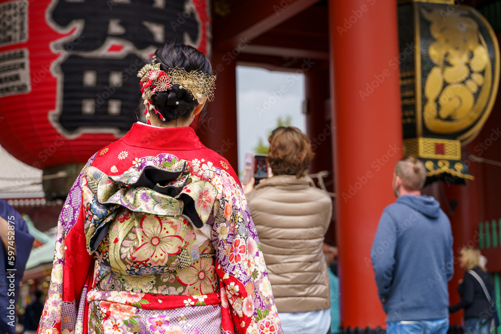 Young girl wearing Japanese kimono standing in front of Sensoji Temple in Tokyo, Japan. Kimono is a Japanese traditional garment. The word Young girl wearing Japanese kimono standing in front of Sensoji Temple in Tokyo, Japan. Kimono is a Japanese traditional garment. The word