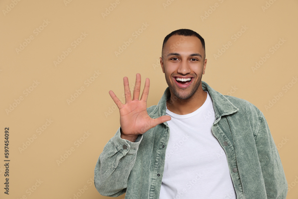 Man giving high five on beige background. Space for text Man giving high five on beige background. Space for text