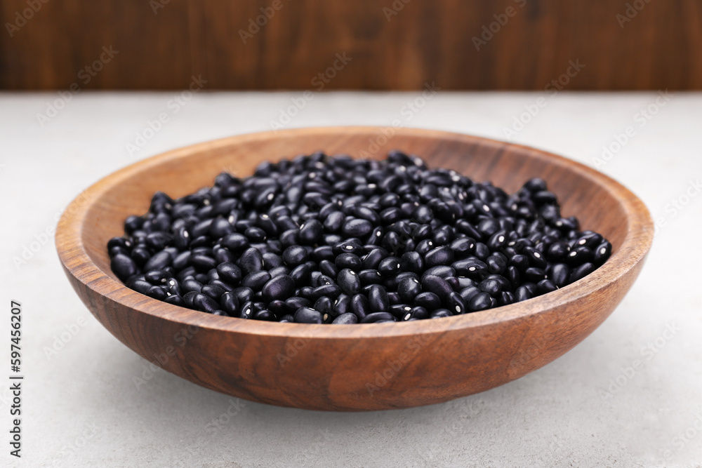 Bowl of raw black beans on light grey table, closeup Bowl of raw black beans on light grey table, closeup