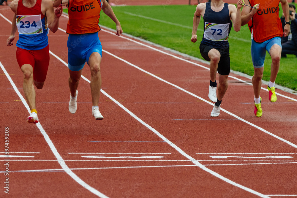 male blind para athletes runners with guides running finish line track stadium, summer para athletics championships