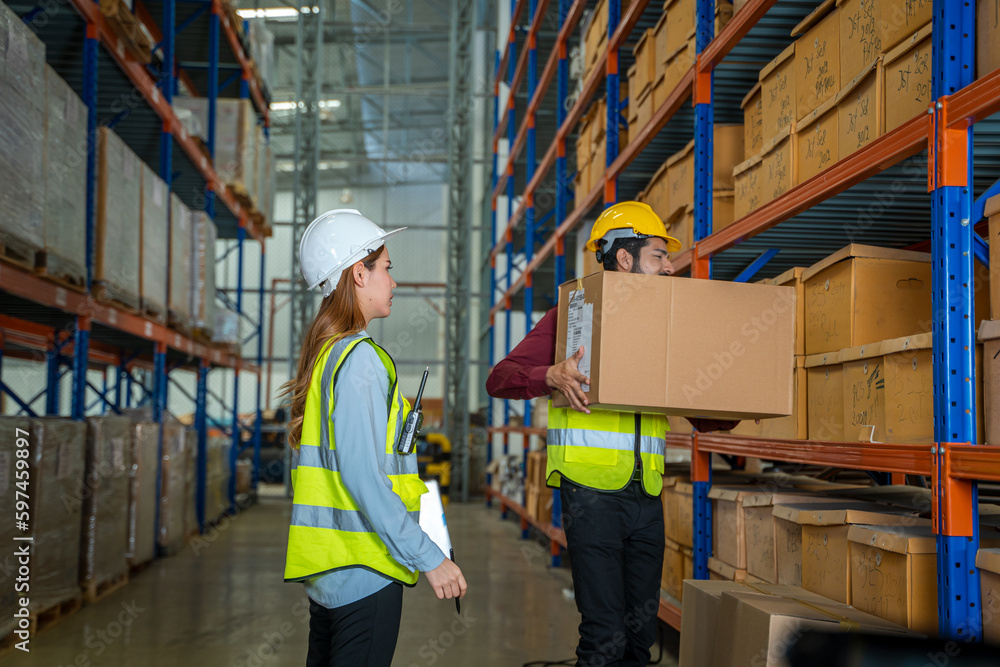 Warehouse employees reading a clipboard ann checking packages on shelf in a large logistics centre. Warehouse employees reading a clipboard ann checking packages on shelf in a large logistics centre.