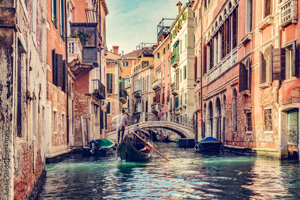 Canal in Venice, Italy with gondolier rowing gondola - obrazy, fototapety, plakaty 