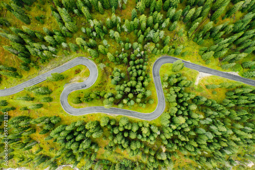 Famous Snake Road surrounded by forests and autumn meadows of Giau Pass. Sightseeing driveway serpentine for cars of Alpine mountains